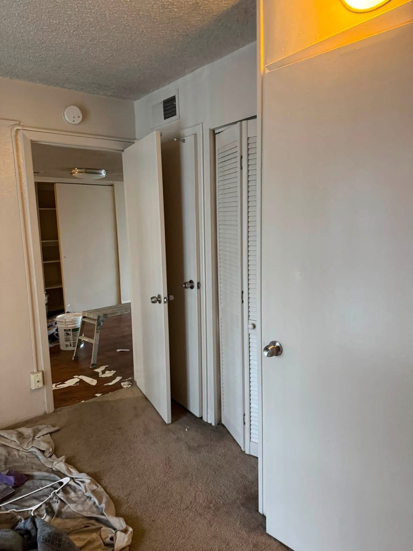 Bedroom interior with carpet flooring, white closet doors, and mirrored closet entrance