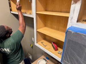 Man installing wooden shelves in wall cabinet during home renovation