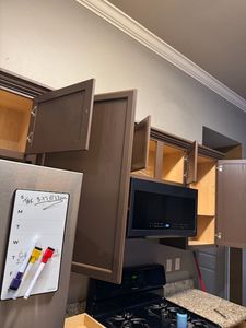 Modern office space with brown wooden cabinets, TV monitor, and whiteboard on wall
