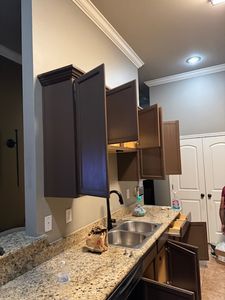 Modern kitchen with dark wood cabinets, granite countertop, and stainless steel sink